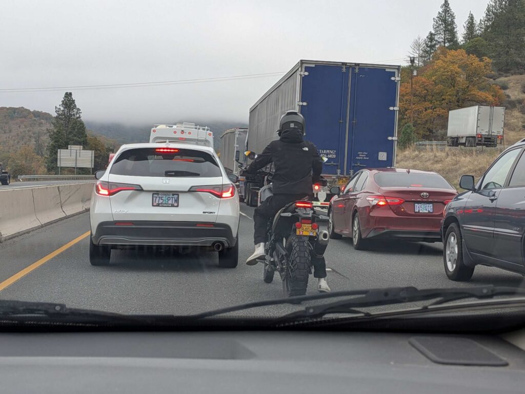 A motorcyclist riding between lines of highway traffic asking is lane splitting legal in Florida.