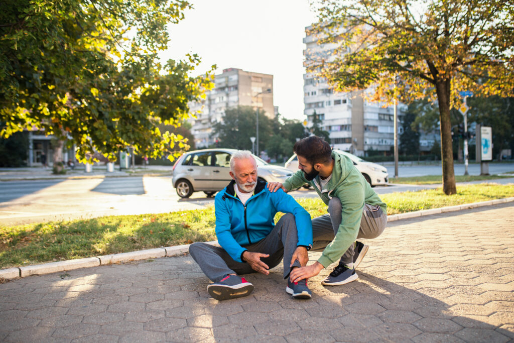 old man hurt being helped by an youger man