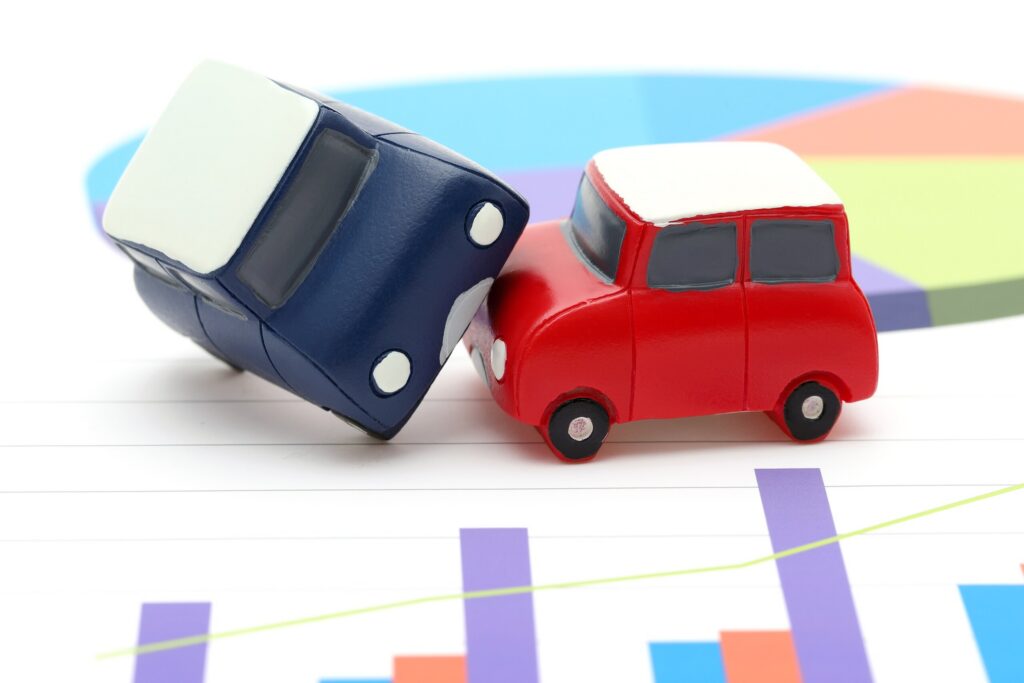 Two toy cars crashing on top of financial data charts reflect key findings from Safety Harbor Car Accident Statistics.