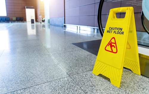 Caution wet floor sign inside Tampa shopping mall warning of slip and fall hazard.