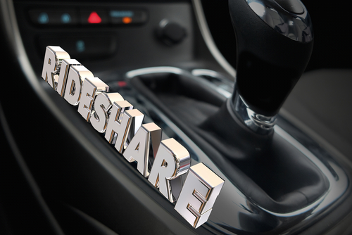 Car gear shift with the word 'Rideshare' in bold, chrome letters, symbolizing ridesharing services.