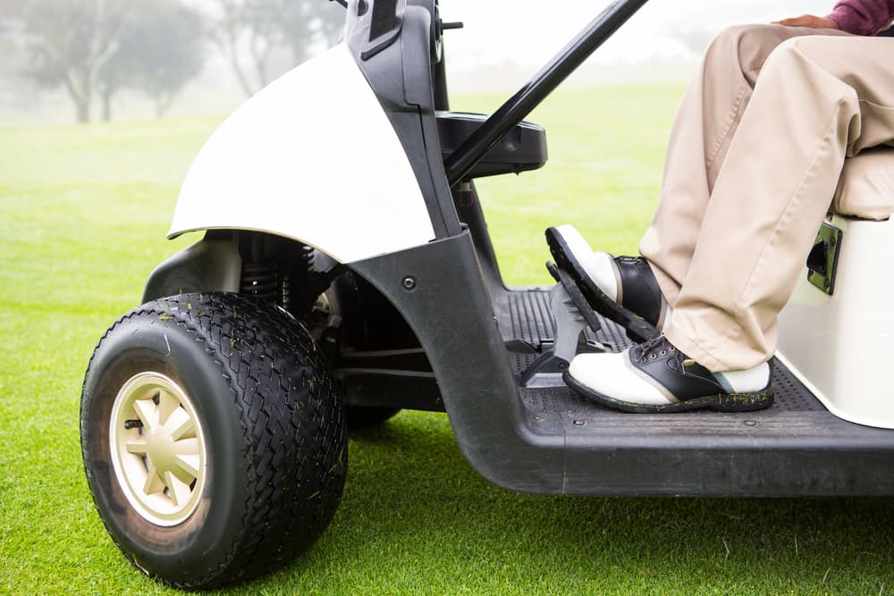 Golfer driving his golf buggy at the golf course