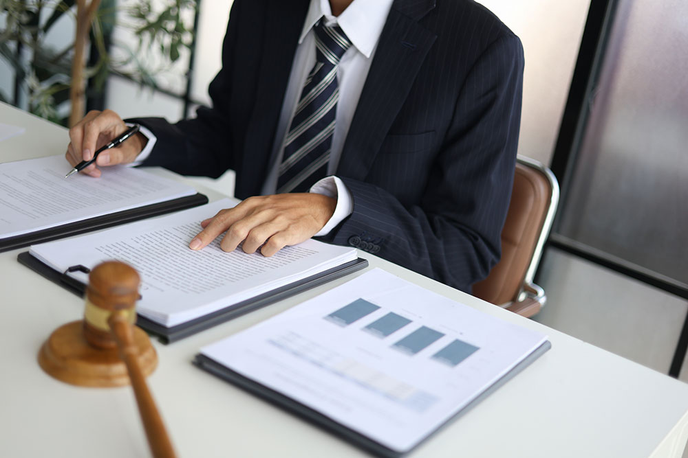 Attorney reviewing legal documents and evidence to prepare a civil assault injury claim.