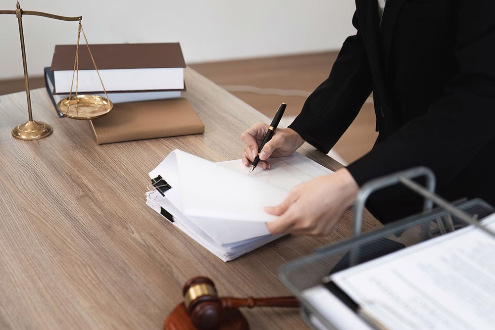 Female lawyer reviewing legal documents in an office while evaluating an insurance dispute.