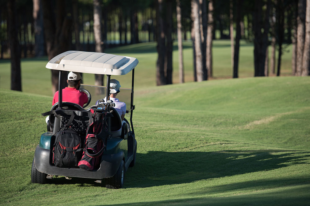 Couple riding in a golf cart on a golf course