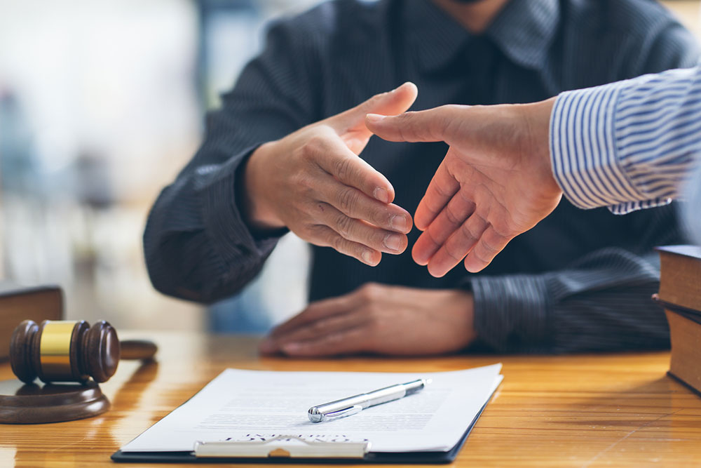 Client shaking hands with a lawyer after discussing a legal agreement