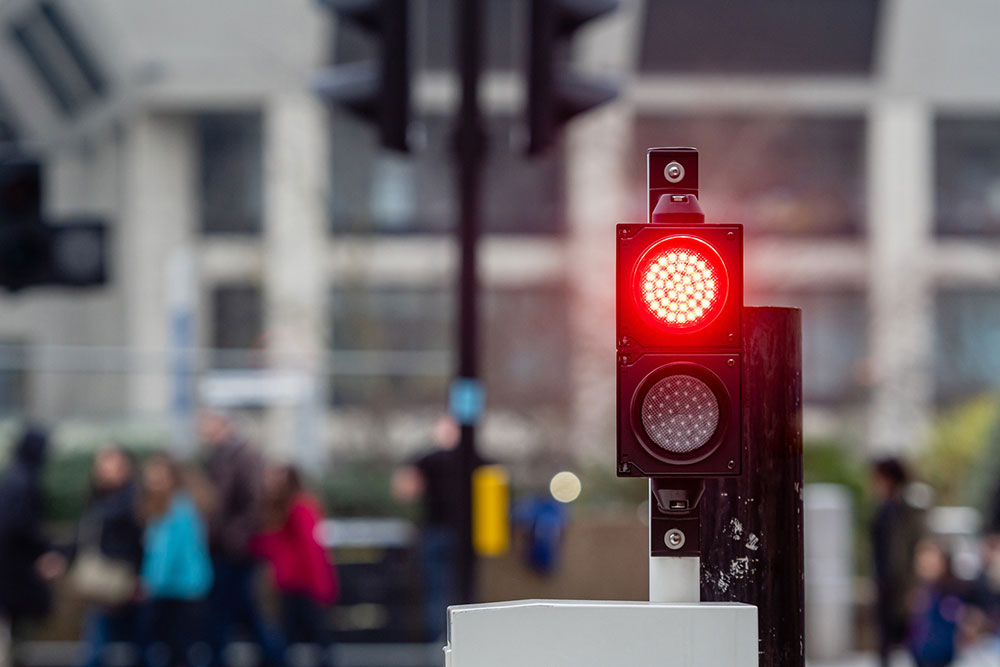 Red traffic light on city street representing a red-light crash