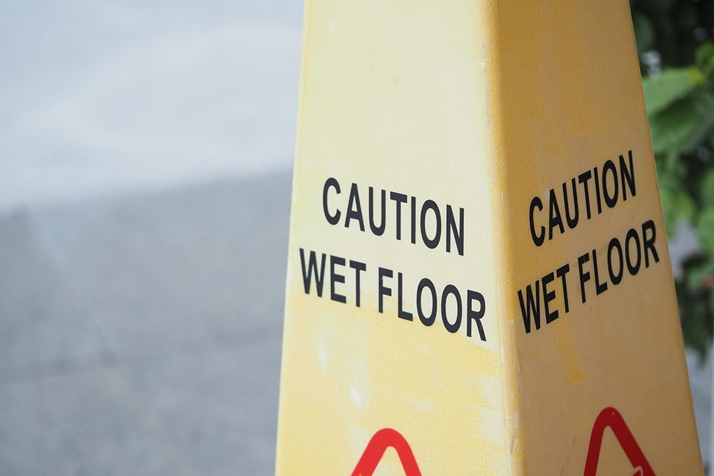 Caution sign indicating a wet floor in a public area representing a slip and fall hazard