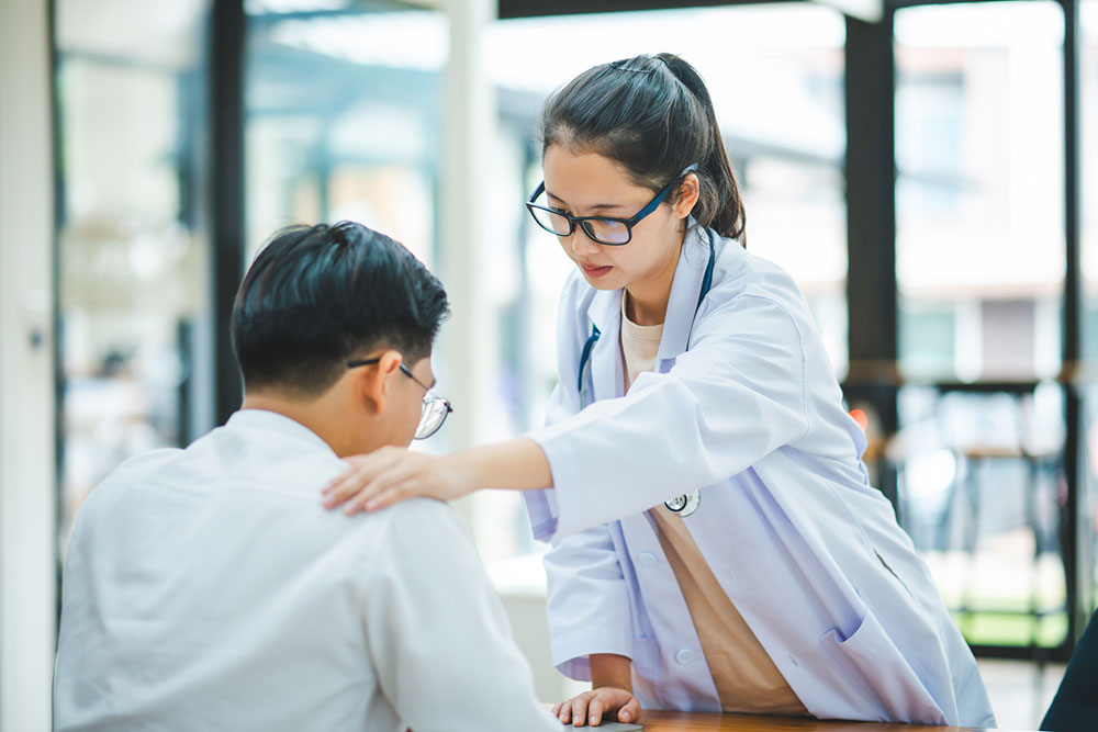 Doctor holding a patient’s hand to provide comfort during treatment after an injury