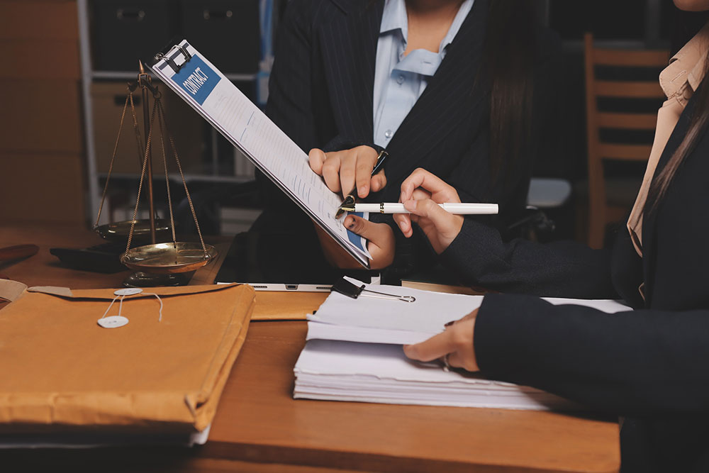 Two professionals reviewing paperwork while preparing a legal claim