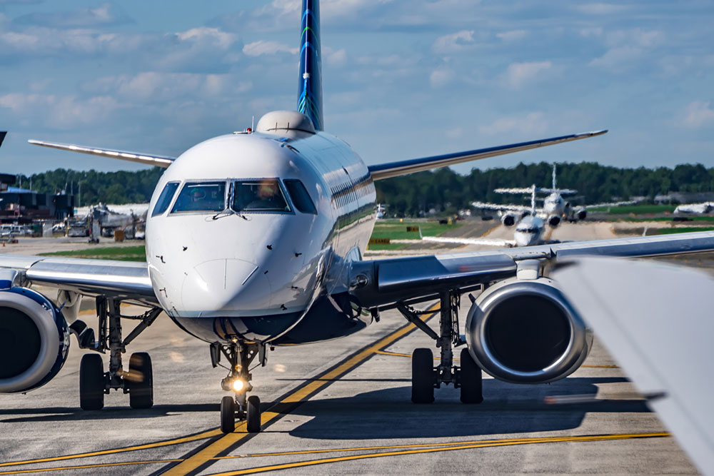Busy airport tarmac with ground vehicles and aircraft preparing for takeoff