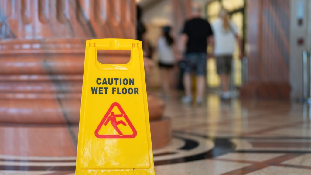 Caution wet floor sign at a New Port Richey supermarket highlighting premises liability risks and customer slip and fall hazards