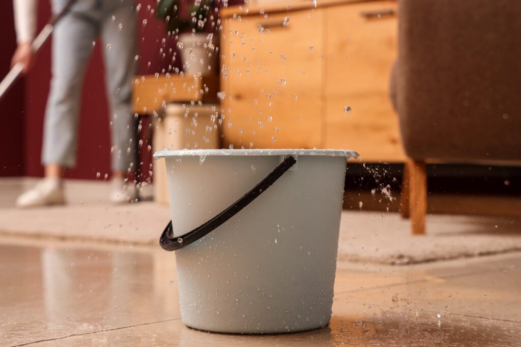 Water splashing near a bucket on a wet floor, illustrating Florida Slip & Fall Laws: Constructive Knowledge.