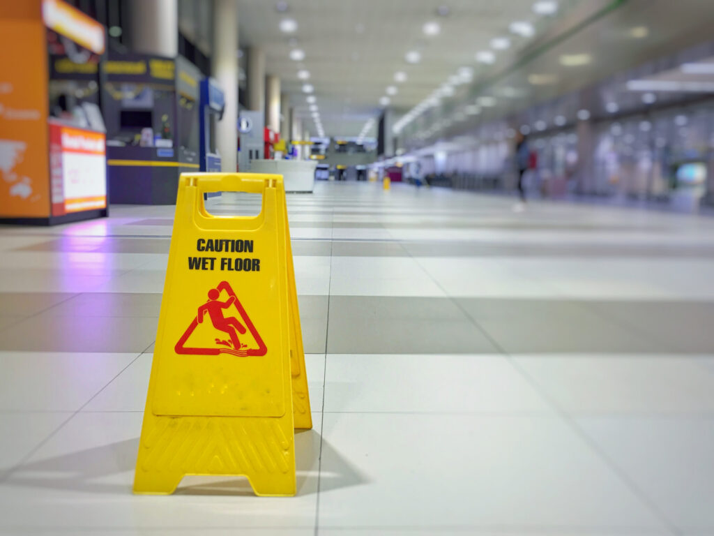 Caution wet floor sign marking hazards handled by Safety Harbor slip and fall accident lawyers.