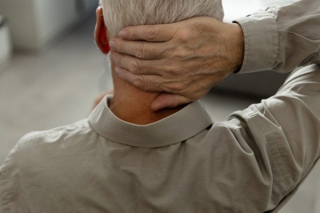 A man holding the back of his head highlights trauma cases represented by Safety Harbor Brain Injury Lawyers.