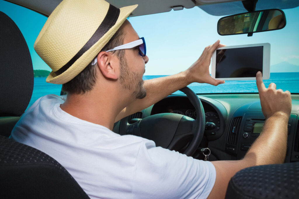 A driver using a digital tablet behind the wheel illustrates dangers linked to Distracted Drivers and Pedestrian Accidents in St. Petersburg.
