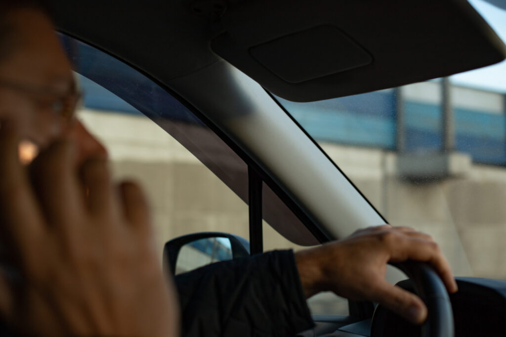 A man talking on his cell phone while driving a vehicle reflects high-risk behaviors tracked in Distracted Driving Statistics in Florida and Safety Harbor.