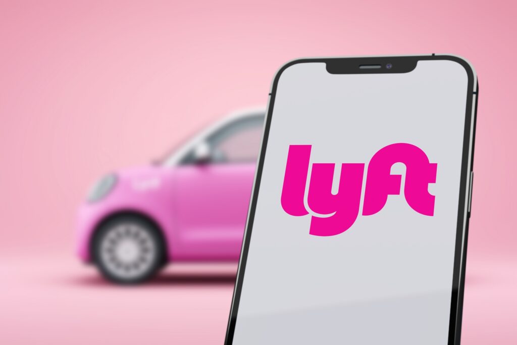 A smartphone showing the Lyft logo next to a toy car highlights issues with Inexperienced Lyft Drivers in St. Petersburg