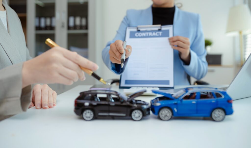 An attorney points to a contract near toy cars to discuss options following a DUI Accident in Safety Harbor: PIP Recovery.