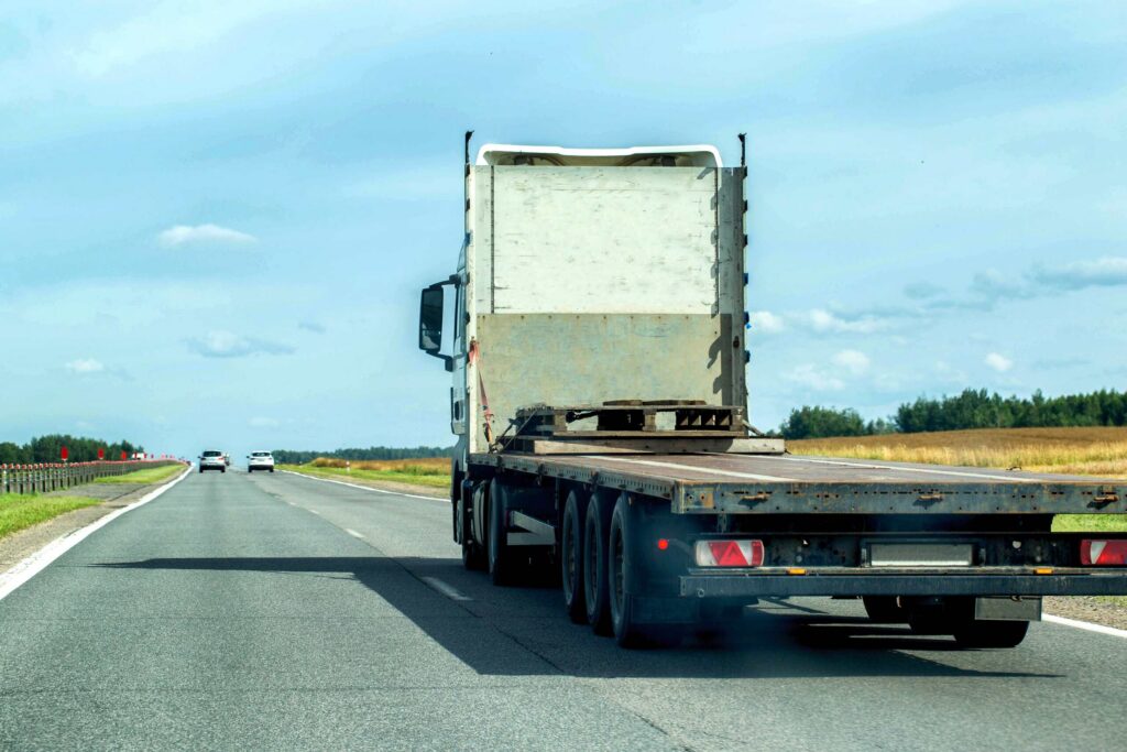 Flatbed commercial truck driving down a open highway illustrating New Port Richey Commercial Truck Routes Liability in US 19 Crashes.