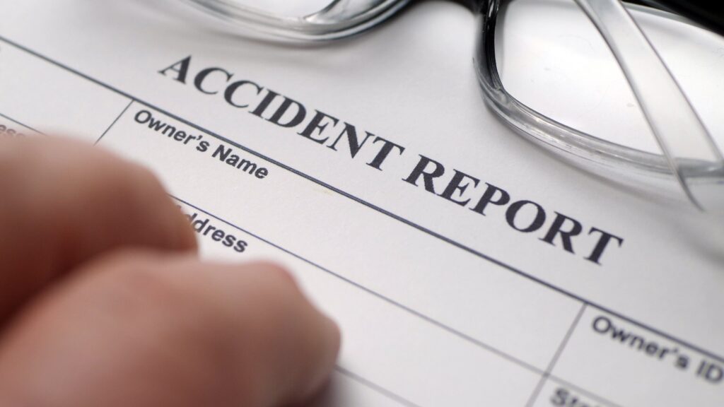 An official accident report form next to eyeglasses for What to Expect When Filing a Personal Injury Claim in New Port Richey Court.