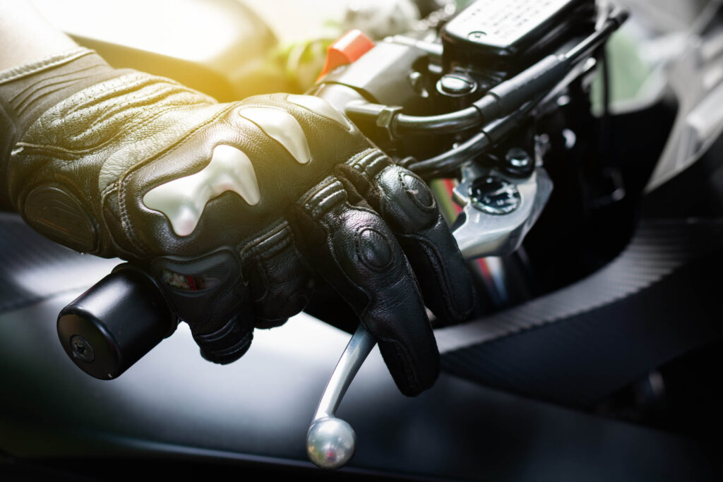 Close up of a rider wearing a leather glove holding the brake lever in a guide on Why Florida PIP Doesn't Cover Your New Port Richey Motorcycle Accident.