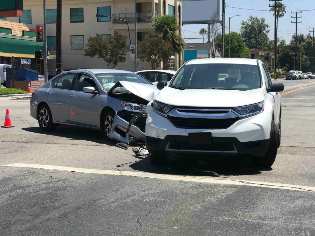 A white car crashed into a box truck at a busy road crossing illustrating the most dangerous intersections for car accidents in New Port Richey.