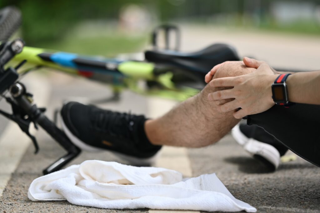 A cyclist holding a injured knee next to a fallen bicycle after an accident on the Pinellas Trail.