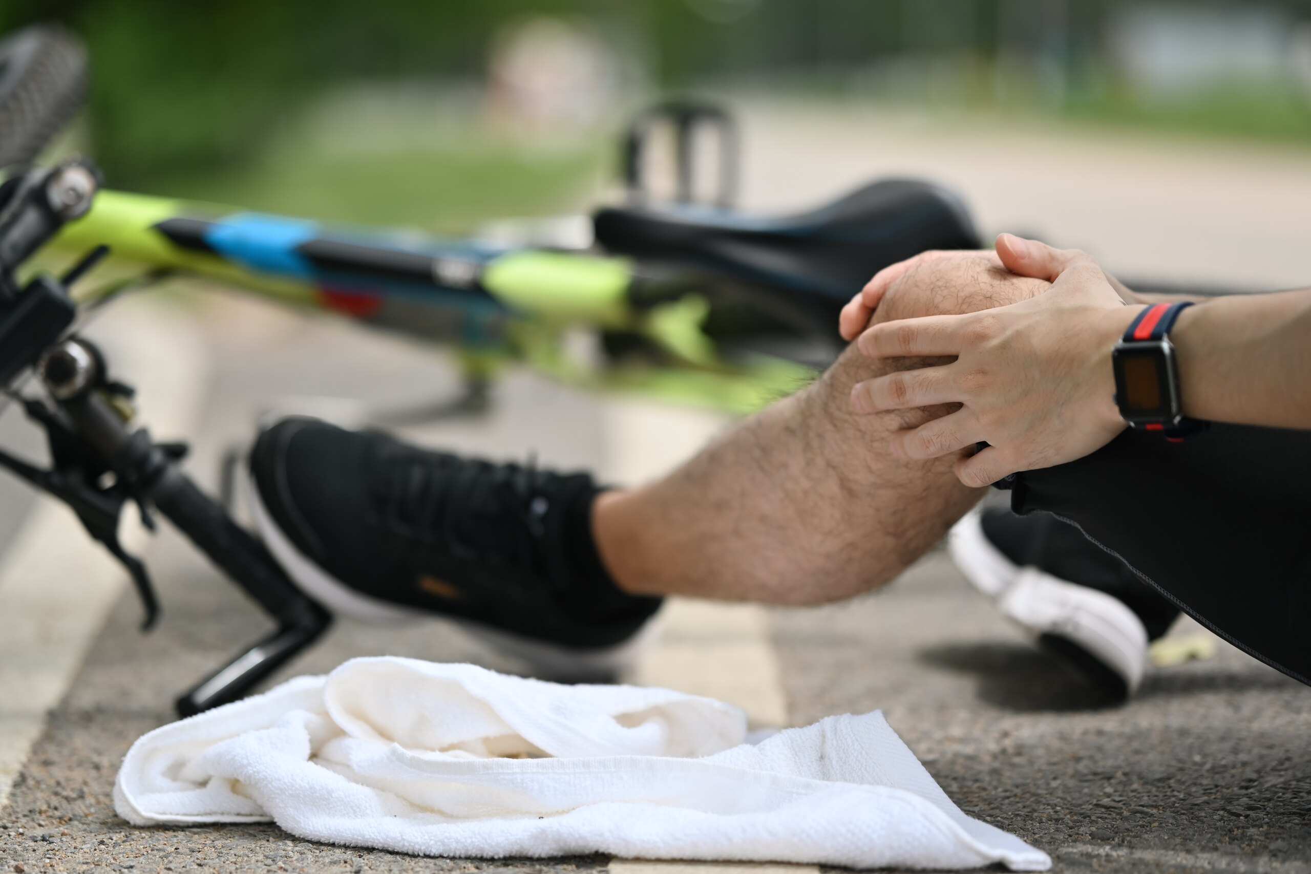A cyclist holding a injured knee next to a fallen bicycle after an accident on the Pinellas Trail.