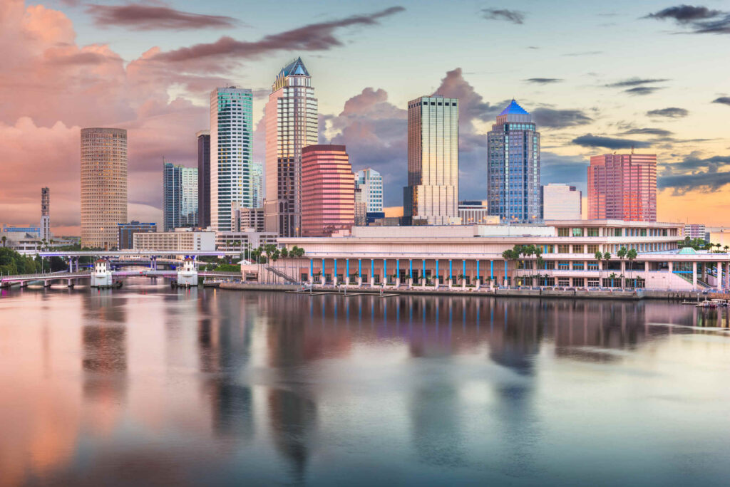 The downtown skyline reflected over the water at sunset in the Tampa Personal Injury legal service area.