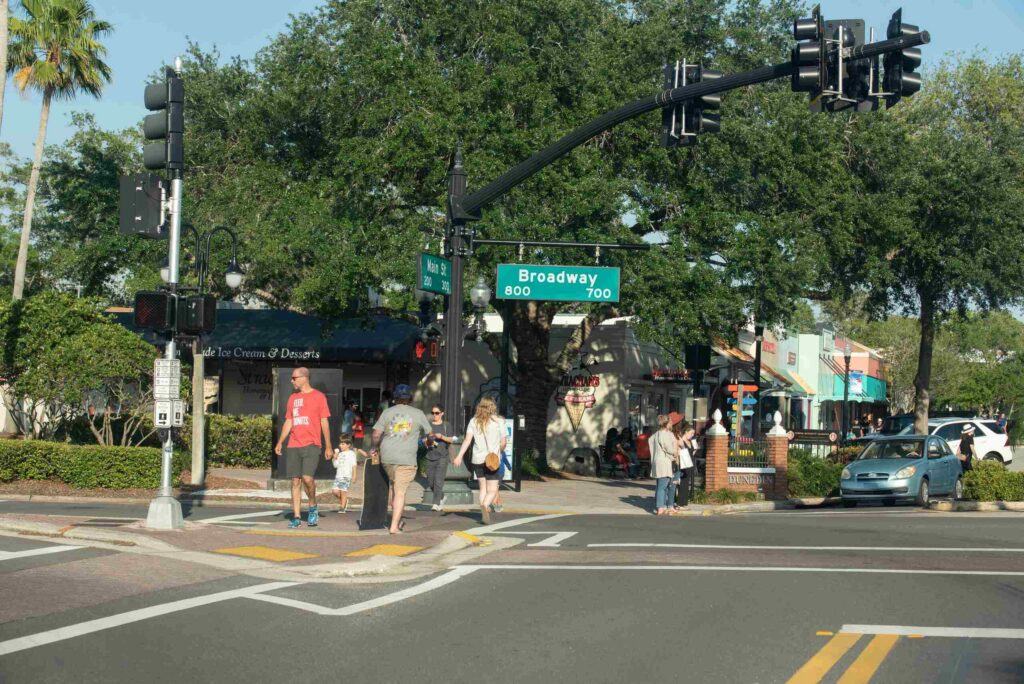 Pedestrians crossing a street at the intersection of Main Street and Broadway in Dunedin Florida.